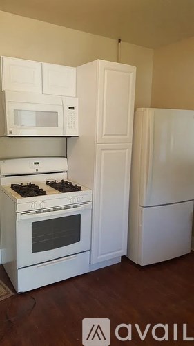 A kitchen with white appliances and cabinets.