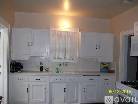 A kitchen with white cabinets and a date stamp of 05/12/2016.