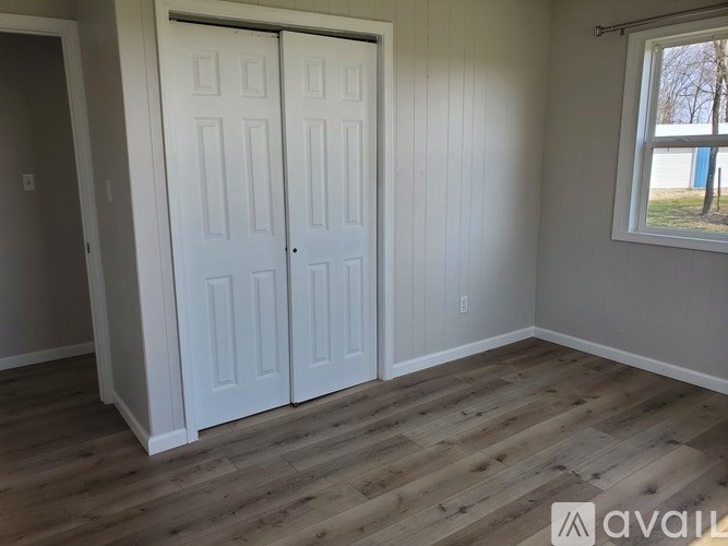 A room with two white doors and a window.