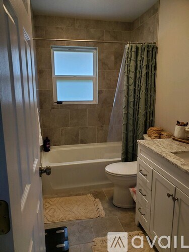A bathroom with a tub, toilet, and sink.