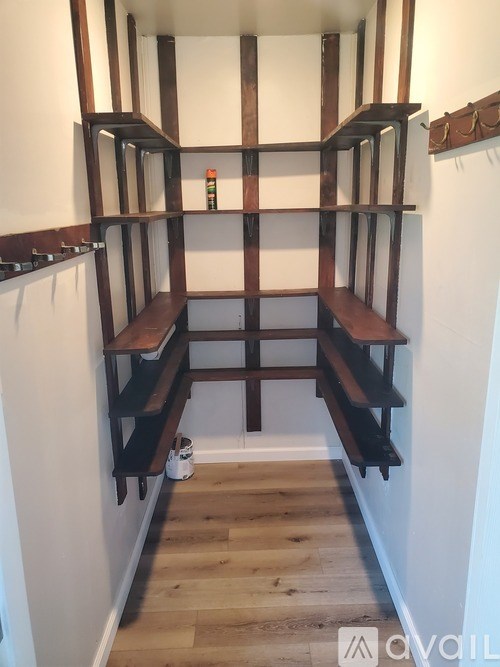 A long hallway with a bench and shelves on the side.