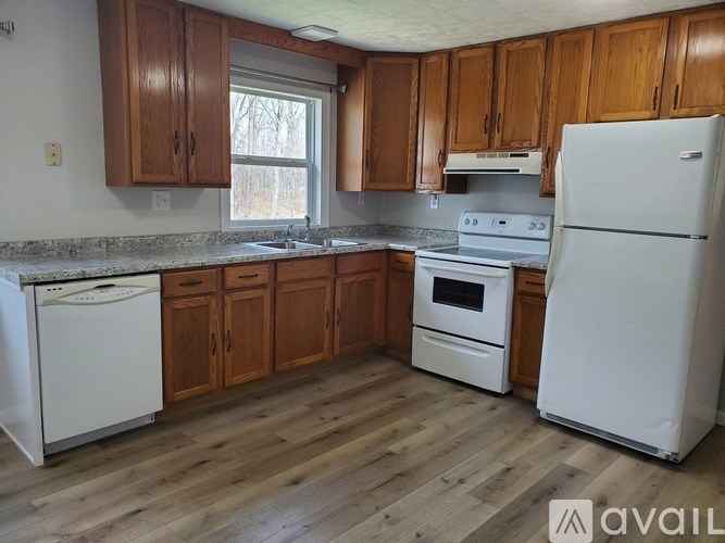 A kitchen with wooden cabinets and white appliances.