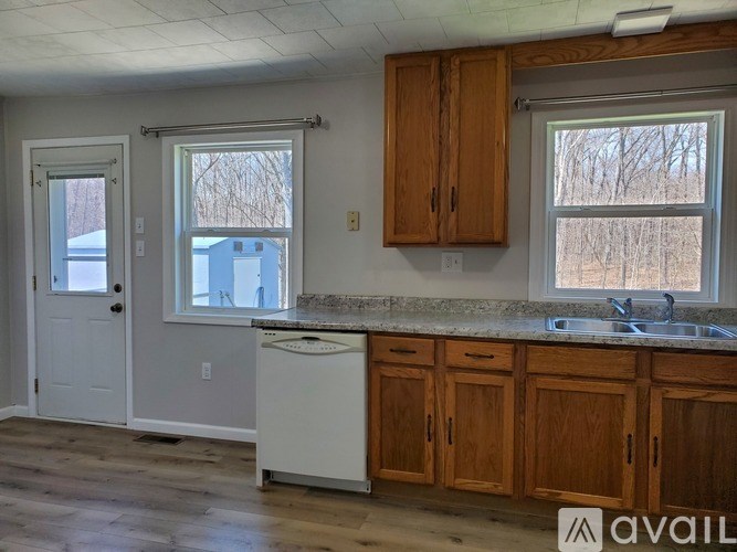 A kitchen with wooden cabinets and a white dishwasher.