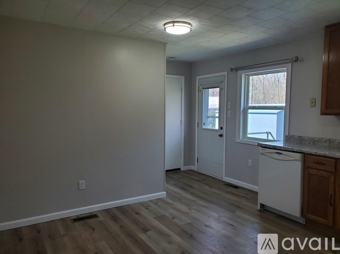 A room with a white door, a window, and a counter.