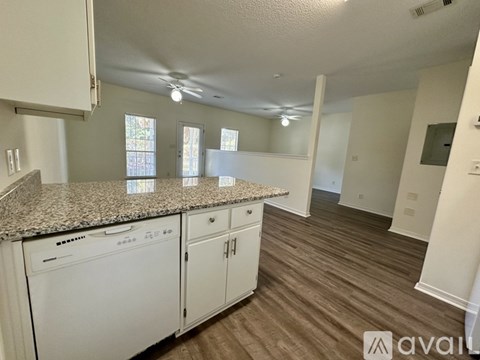 A kitchen with white cabinets and a granite countertop.