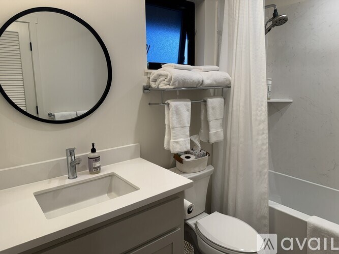 A bathroom with a sink, toilet, and a shower curtain.