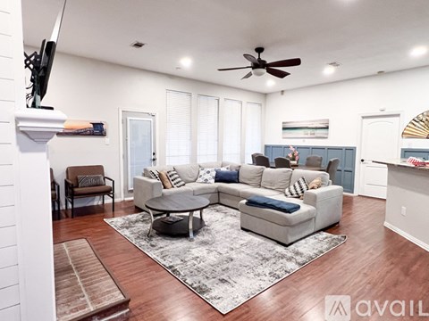 A living room with a white couch and a grey coffee table.