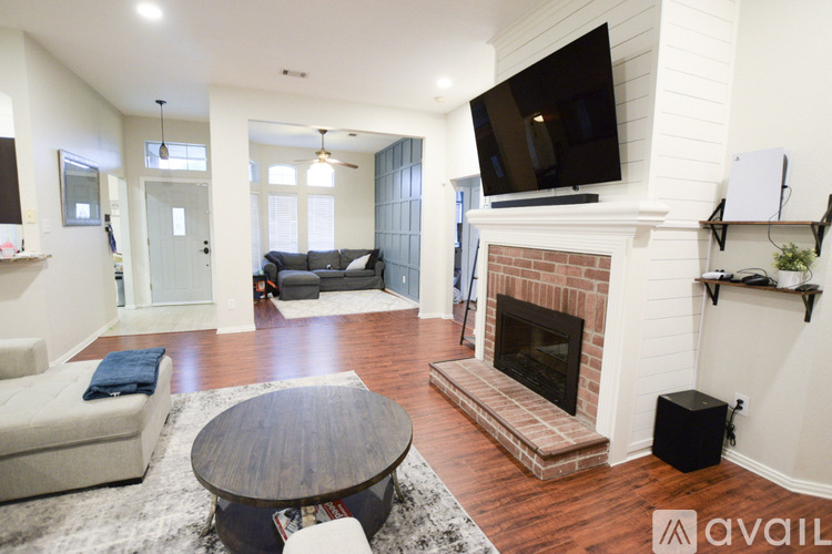 A living room with a fireplace and a television mounted on the wall.