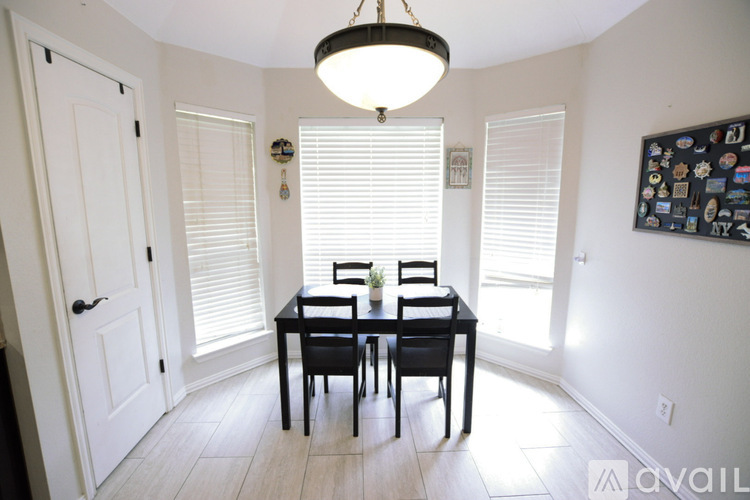 A dining room with a table and chairs.