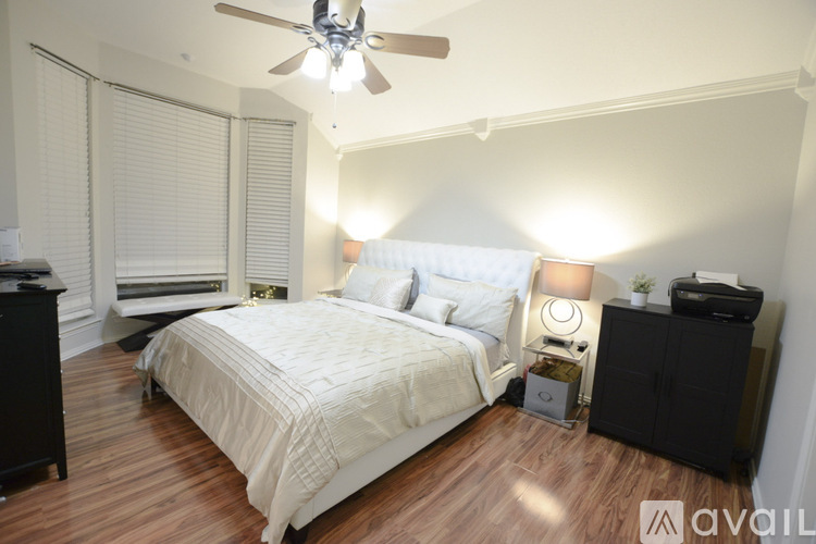 A bedroom with a bed, nightstand, and a ceiling fan.