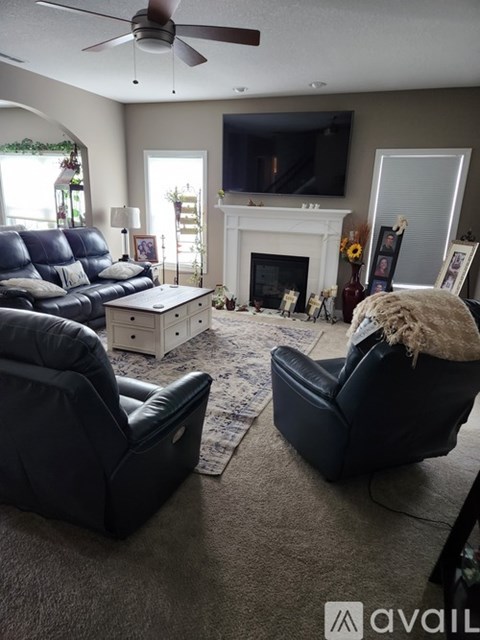 A living room with a black leather chair and a white coffee table.