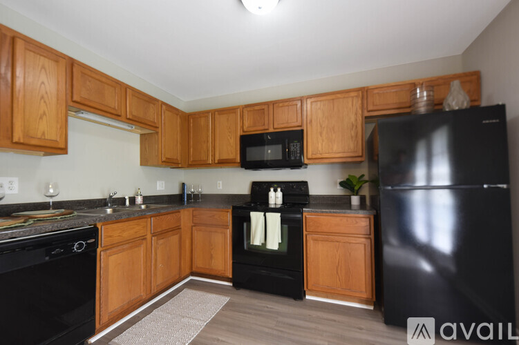 A kitchen with black appliances and wooden cabinets.