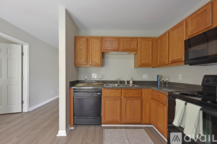 A kitchen with wooden cabinets and a black oven.