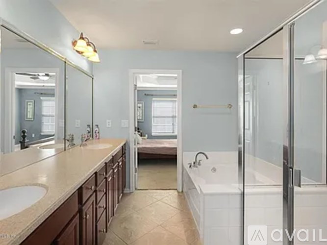A bathroom with a sink, mirror, and bathtub.