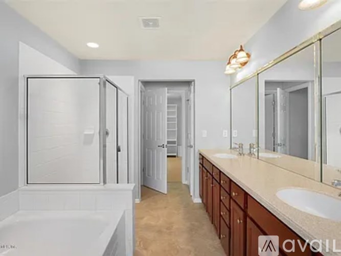 A bathroom with a white tub and a sink with a mirror above it.