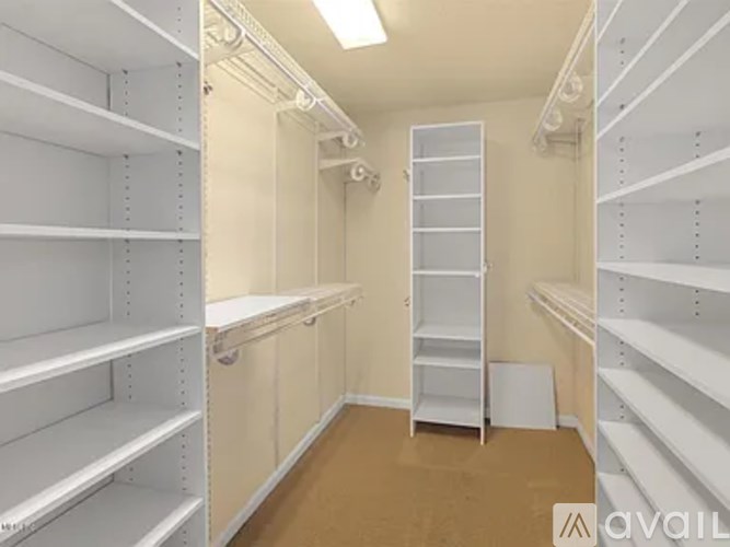 A storage room with white shelves and a brown floor.