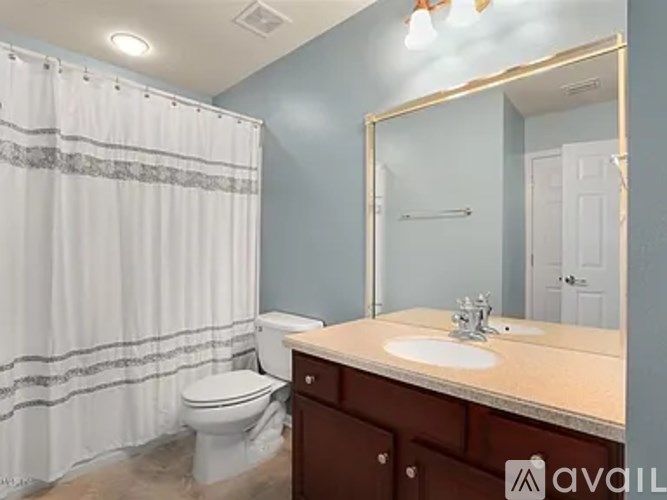 A bathroom with a toilet, sink, and shower curtain.