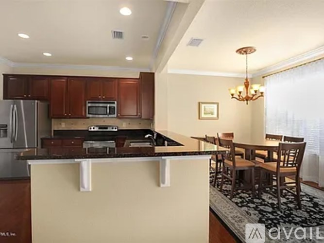 A kitchen with brown cabinets and a white island.