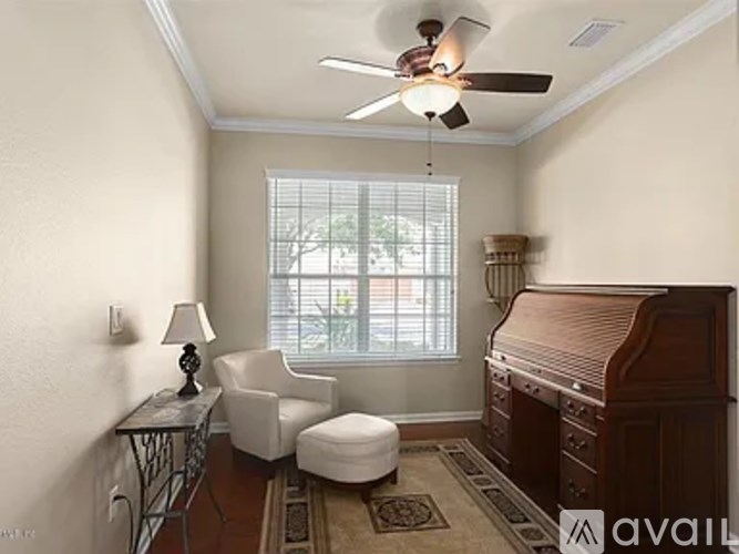 A living room with a piano, chair, and table.