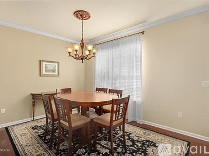A dining room with a table and chairs.