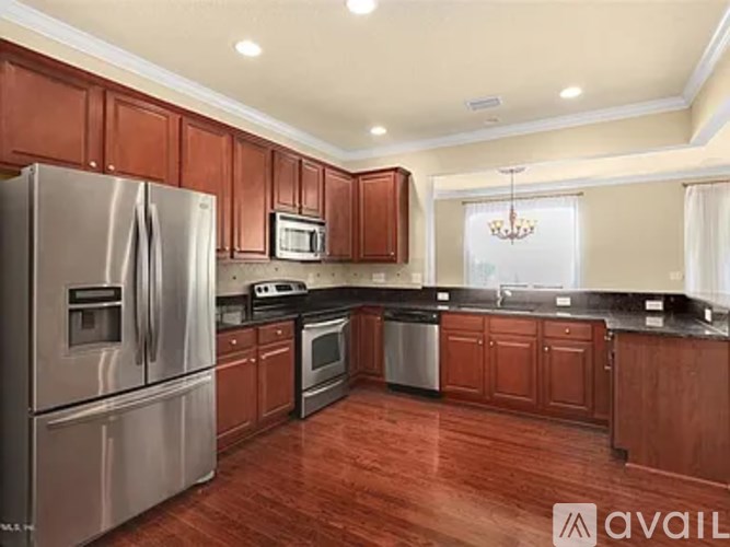 A kitchen with wooden cabinets and a stainless steel refrigerator.