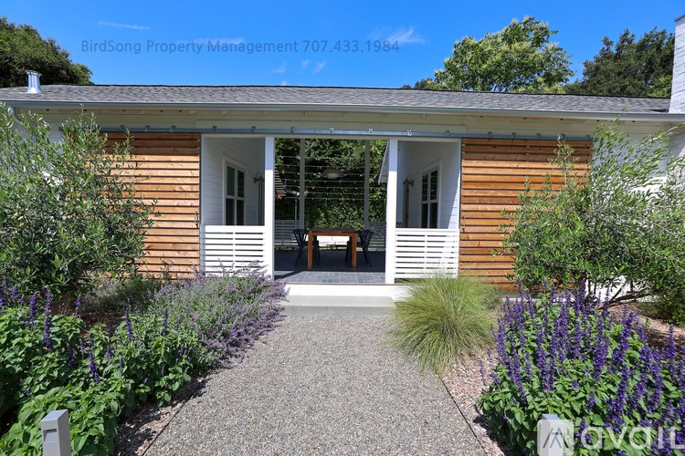 A house with a front porch and a garden in front.
