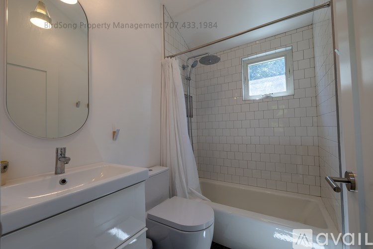 A white bathroom with a toilet, sink, and bathtub.