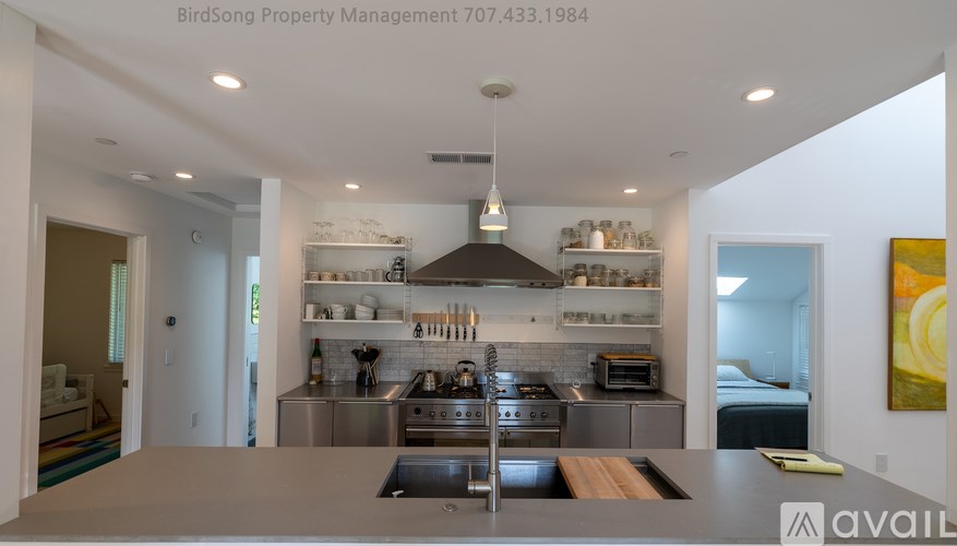 A modern kitchen with stainless steel appliances and a wooden island.
