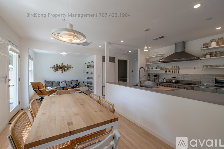 A modern kitchen with a long wooden table and chairs.