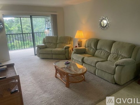 A living room with a glass table and two couches.