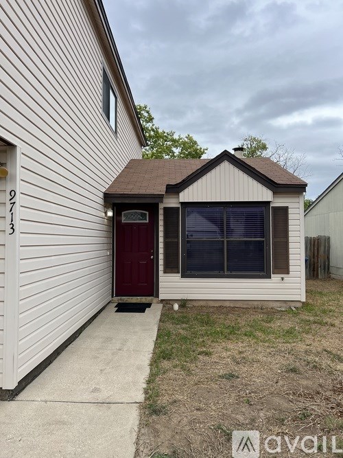 A small house with a red door and a brown roof.