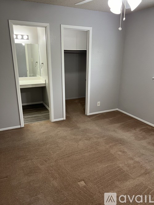 A room with a carpeted floor and two open doors.