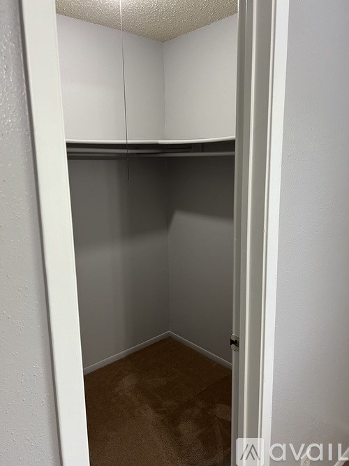 A small, empty room with a brown carpet.