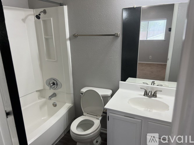 A bathroom with a toilet, sink, and bathtub.