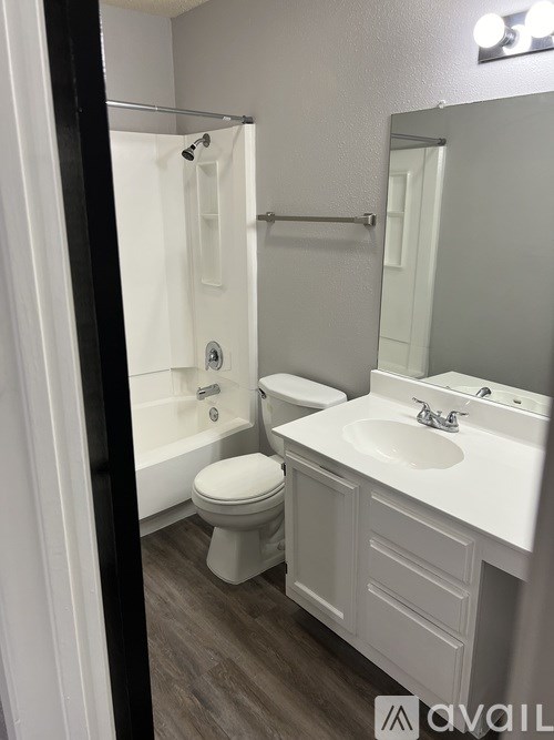 A white bathroom with a toilet, sink, and shower.