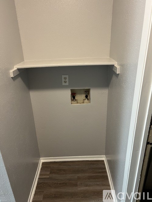 A small room with a white shelf and a window.