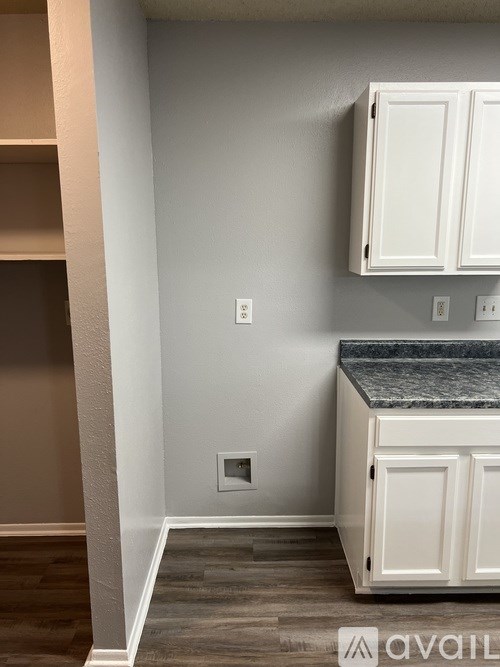 A kitchen with a granite countertop and white cabinets.
