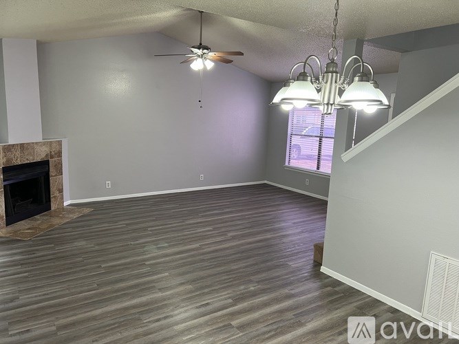 A living room with a fireplace and wood flooring.