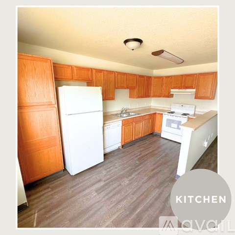 A kitchen with wooden cabinets and white appliances.