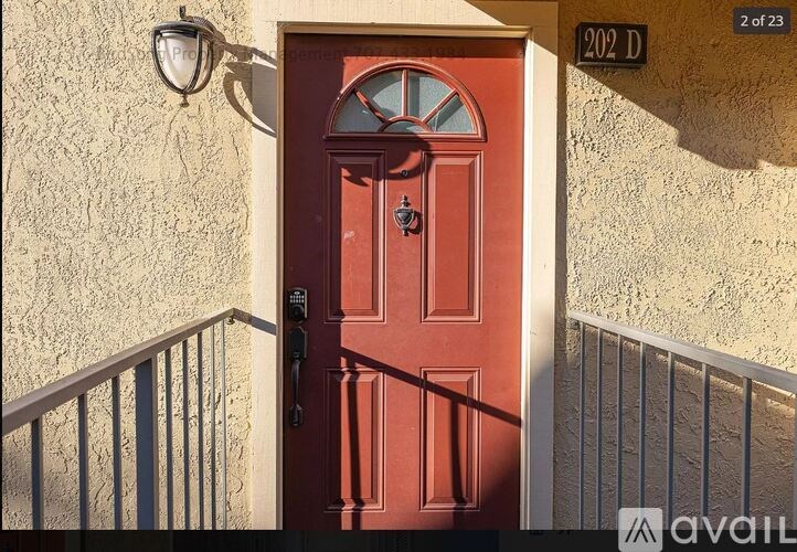 A red door with a glass window above it and a metal railing below it.