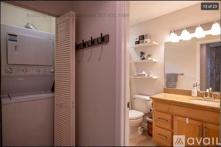 A small bathroom with a toilet, sink, and a refrigerator.