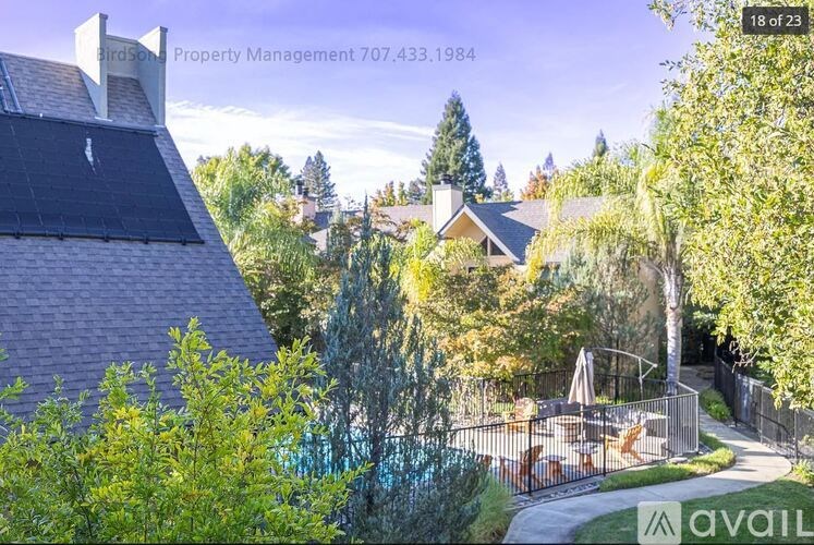 A house with a fence and trees in the background.