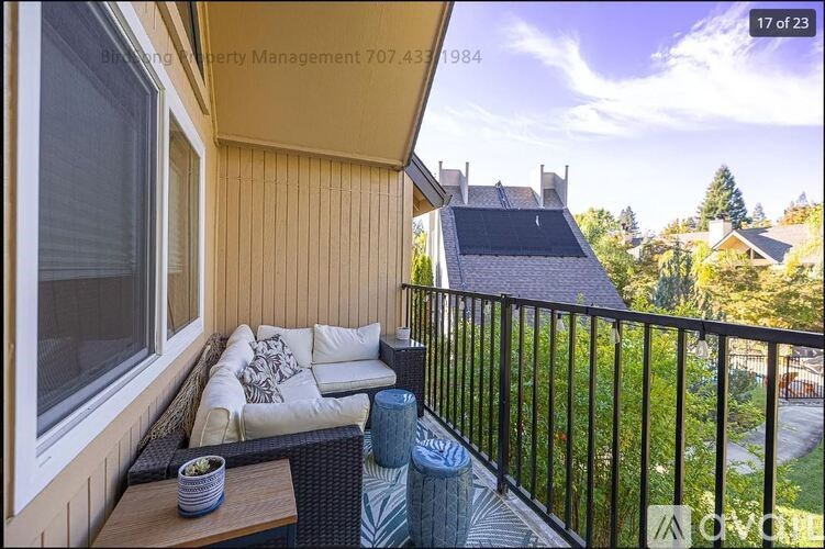 A balcony with a sofa and a table with a bowl on it.