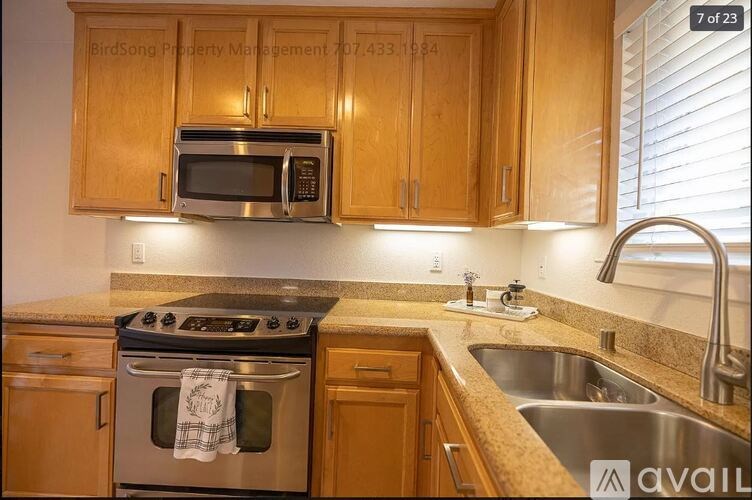 A kitchen with wooden cabinets and a stove top oven.