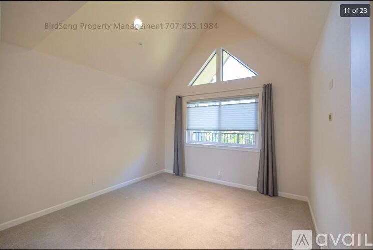 A room with a window and a triangular skylight is available for rent.
