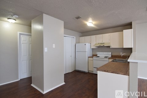 A kitchen with white appliances and cabinets.