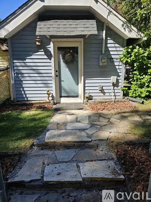 A house with a blue door and a stone pathway leading to it.