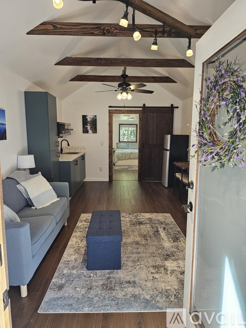 A living room with a grey couch and a wooden floor.
