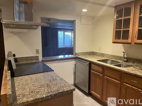 A kitchen with granite countertops and wooden cabinets.