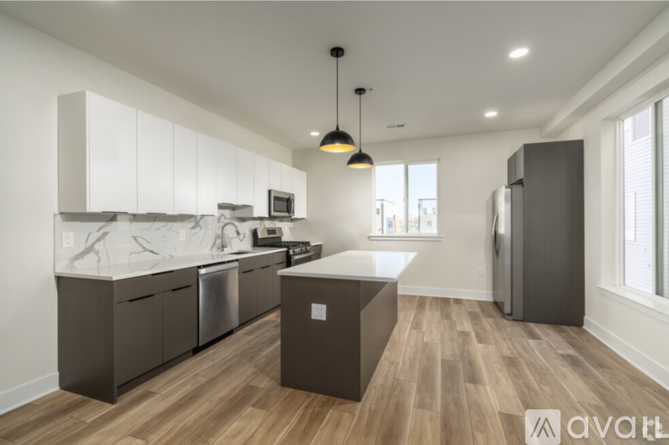A modern kitchen with wooden floors and a large island.
